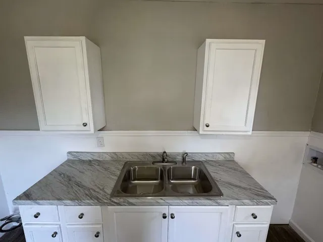 a kitchen with granite countertop white cabinets and white appliances