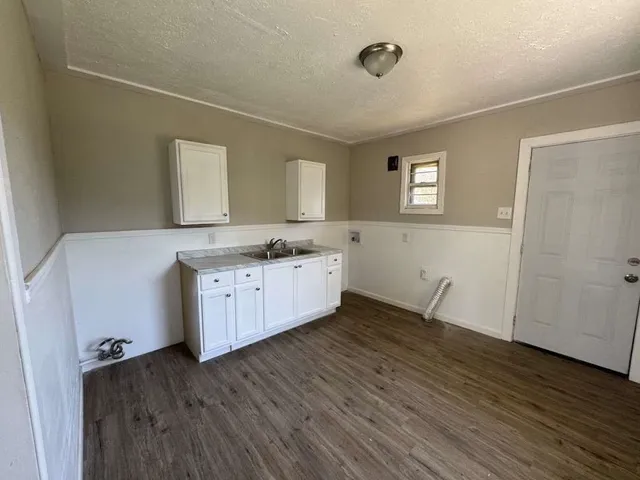 a room with a sink cabinets and wooden floor