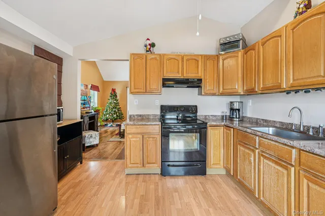 a kitchen with stainless steel appliances granite countertop a refrigerator a stove top oven and a sink