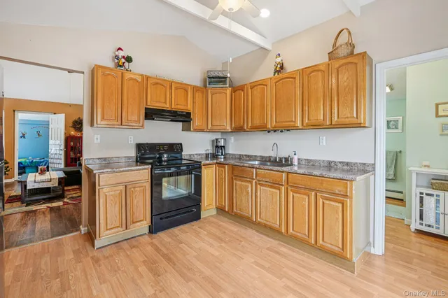 a kitchen with granite countertop a stove top oven sink and cabinets
