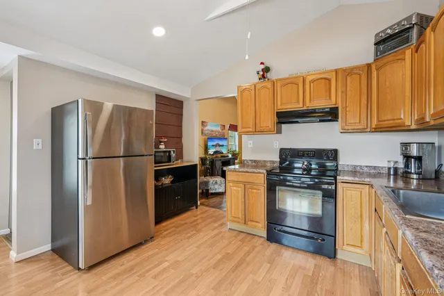 a kitchen with granite countertop a refrigerator stove top oven and sink