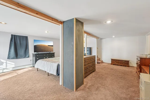 a large white bed sitting in a room next to a window