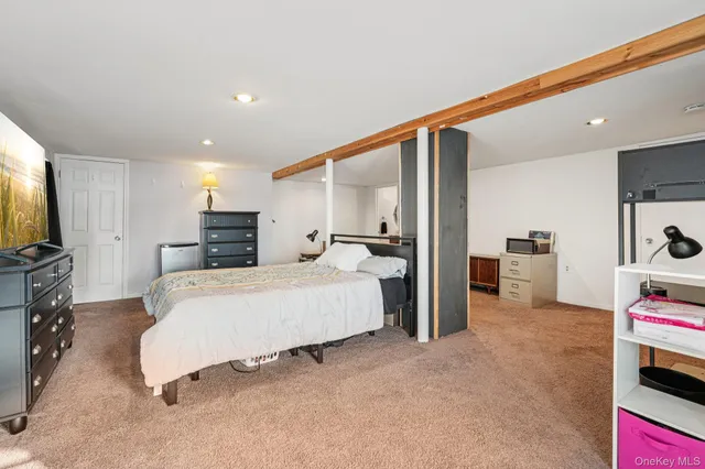 a bedroom with a large bed and a flat tv screen