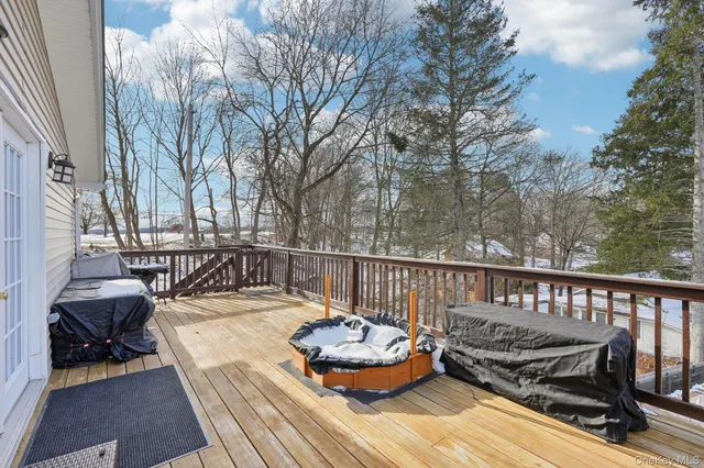 a view of a deck with couches table and chairs with wooden floor and fence