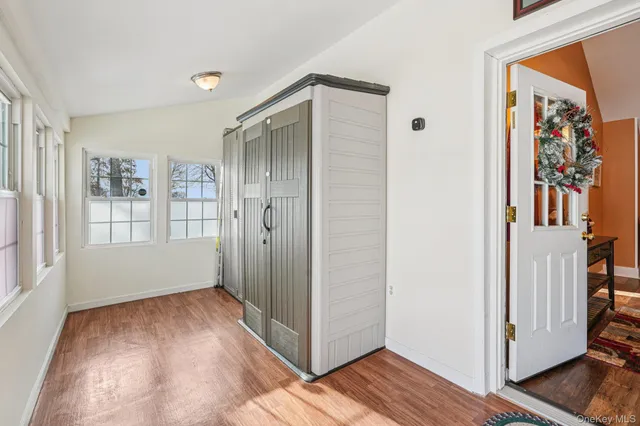 a view of a hallway with wooden floor and windows