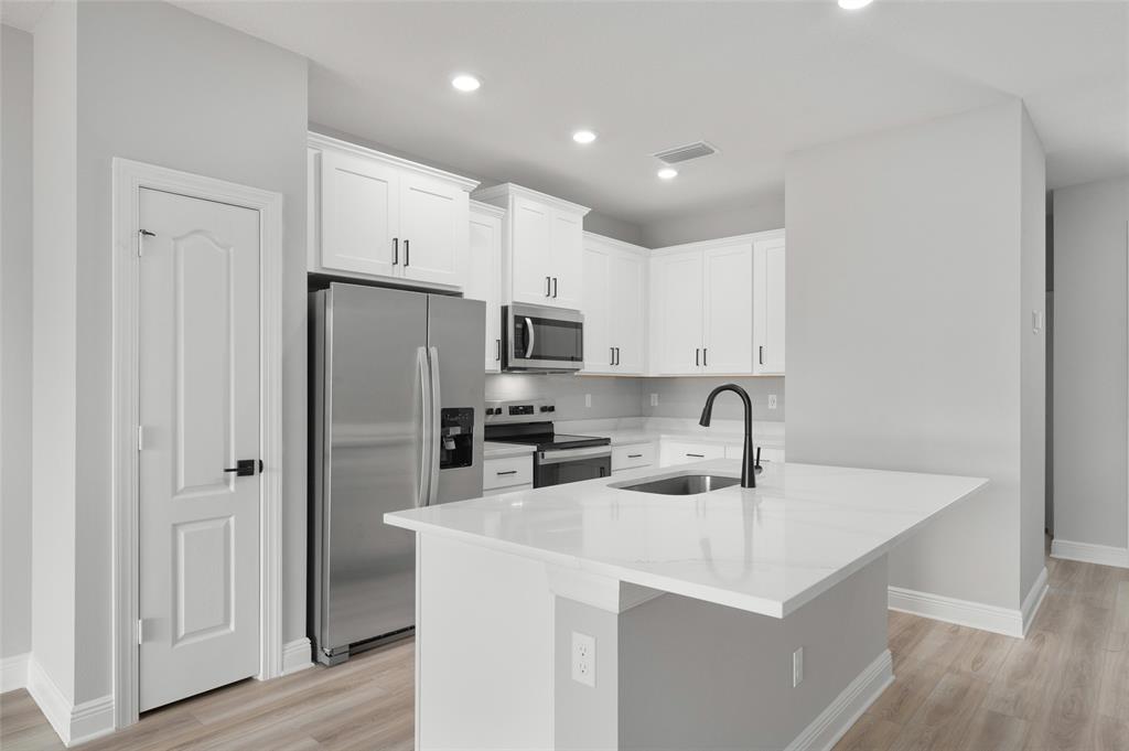 1813 Gaiety Way Fort Pierce, FL 34947 - Photo 3 of 16 a kitchen with stainless steel appliances a refrigerator sink and cabinets