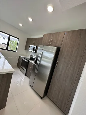 a view of kitchen with furniture and refrigerator