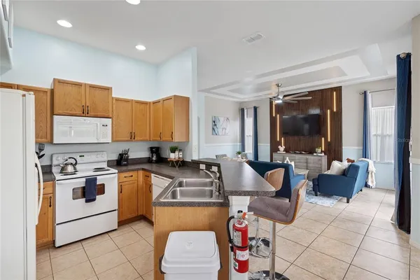 a kitchen with stainless steel appliances granite countertop a stove a sink dishwasher a dining table and chairs with wooden floor