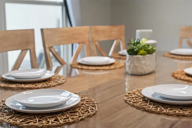 a table with a vase and a vase on it with table and chairs