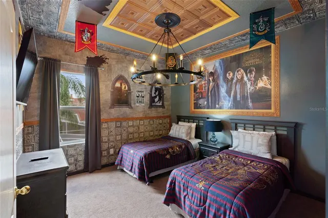 a bedroom with two beds and a chandelier