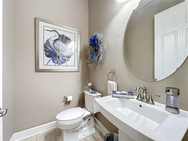 a bedroom with a bed a chair and potted plant on the dresser