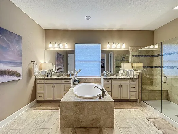 a large white kitchen with a stove a sink a refrigerator and a dining table