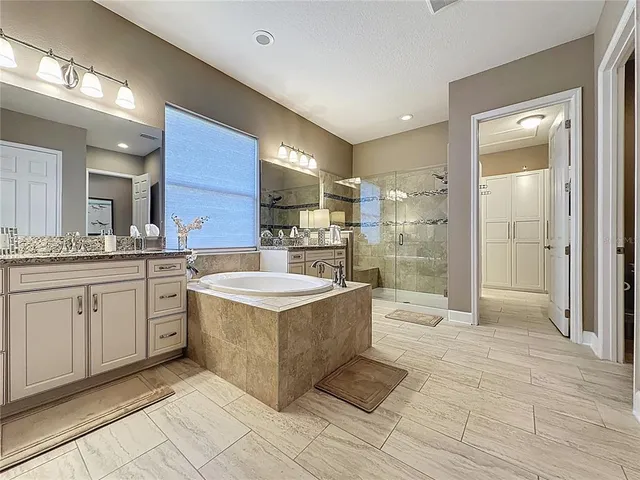 a bathroom with a granite countertop sink a mirror and shower