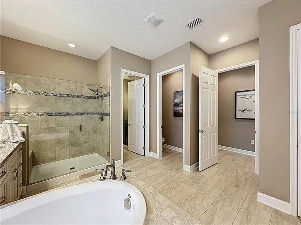 a utility room with stainless steel appliances granite countertop a stove and a refrigerator with white cabinets