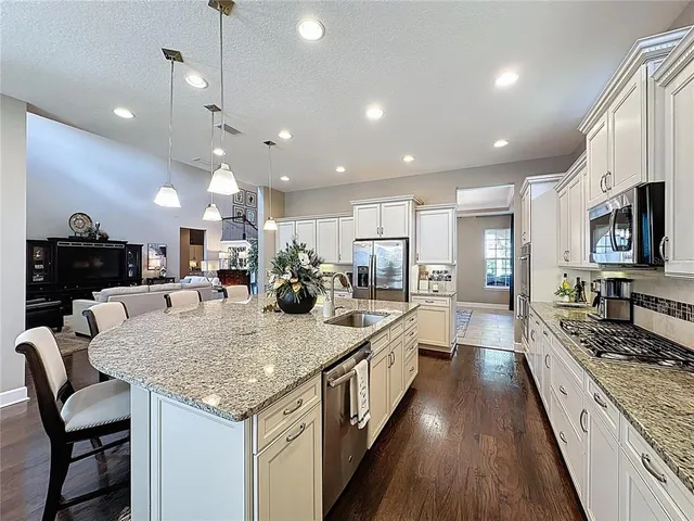 a kitchen with stainless steel appliances granite countertop sink stove top oven and refrigerator