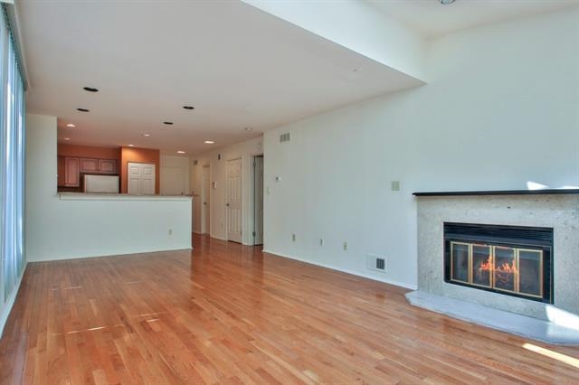 700 Mainsail Lane, Unit 700 Secaucus, NJ 07094 - Photo 2 of 28 an empty room with wooden floor fireplace and windows