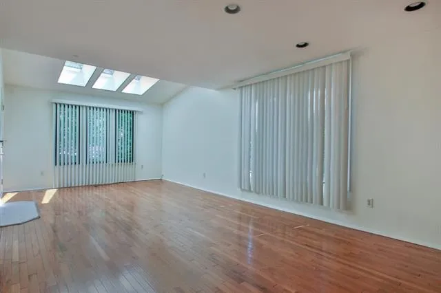 a view of an empty room with wooden floor