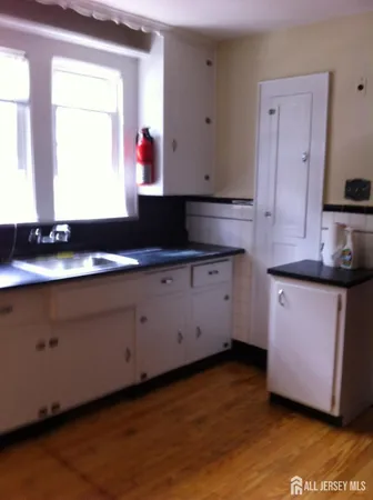 a kitchen with granite countertop white cabinets sink and a granite counter top