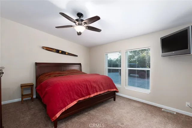 a view of a hallway with wooden floor and a bathroom