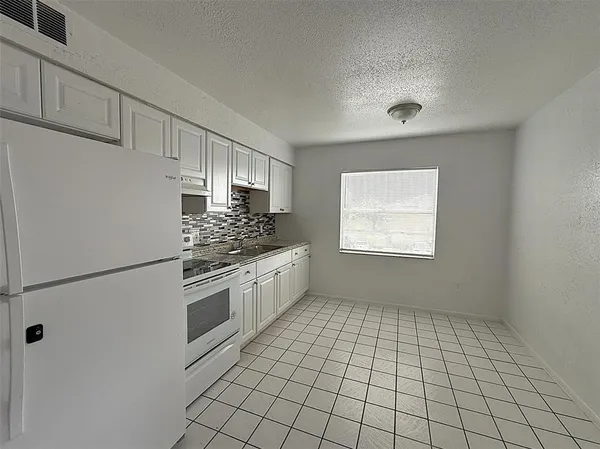 a view of a hallway with a livingroom and a kitchen