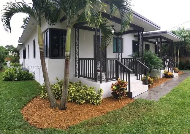 a view of a house with backyard and sitting area