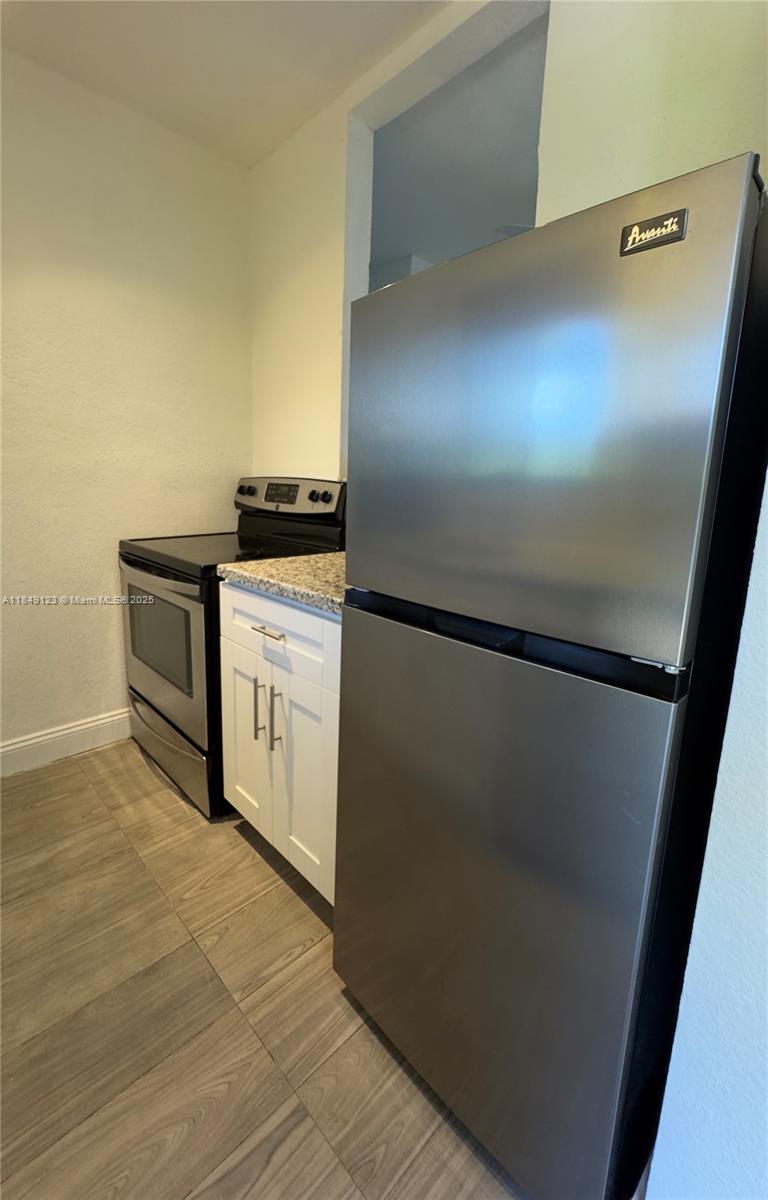 560 Northeast 69th Street, Unit 1 Miami, FL 33138 - Photo 12 of 23 a kitchen with a refrigerator and a stove