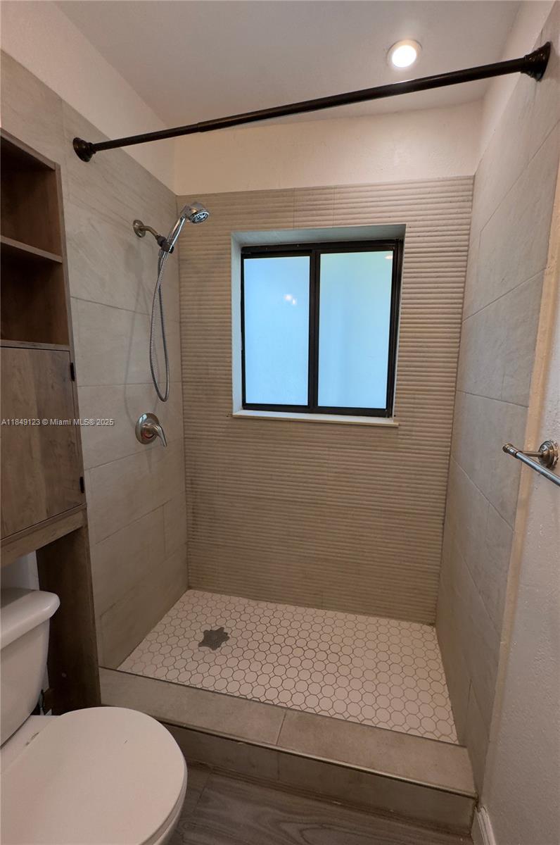 560 Northeast 69th Street, Unit 1 Miami, FL 33138 - Photo 15 of 23 a bathroom with a granite countertop sink toilet and shower