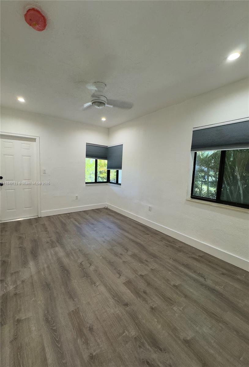 560 Northeast 69th Street, Unit 1 Miami, FL 33138 - Photo 18 of 23 an empty room with wooden floor and windows
