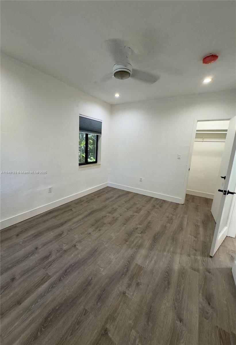 560 Northeast 69th Street, Unit 1 Miami, FL 33138 - Photo 19 of 23 an empty room with wooden floor and windows