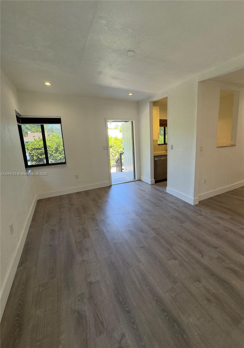 560 Northeast 69th Street, Unit 1 Miami, FL 33138 - Photo 7 of 23 an empty room with wooden floor and windows