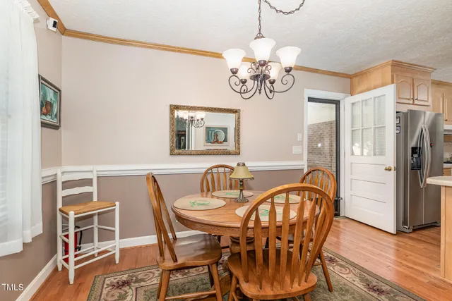 a view of a dining room with furniture wooden floor and chandelier