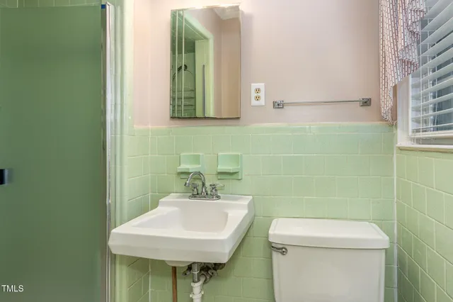 a bathroom with a toilet sink and mirror