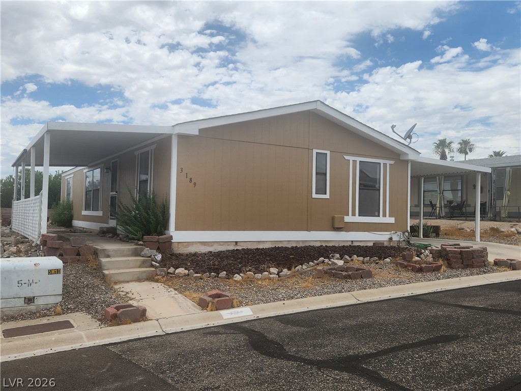 3189 Del Monte Street Laughlin, NV 89029 - Photo 3 of 32 A classic ranch home features a shaded porch, offering a relaxing outdoor retreat.