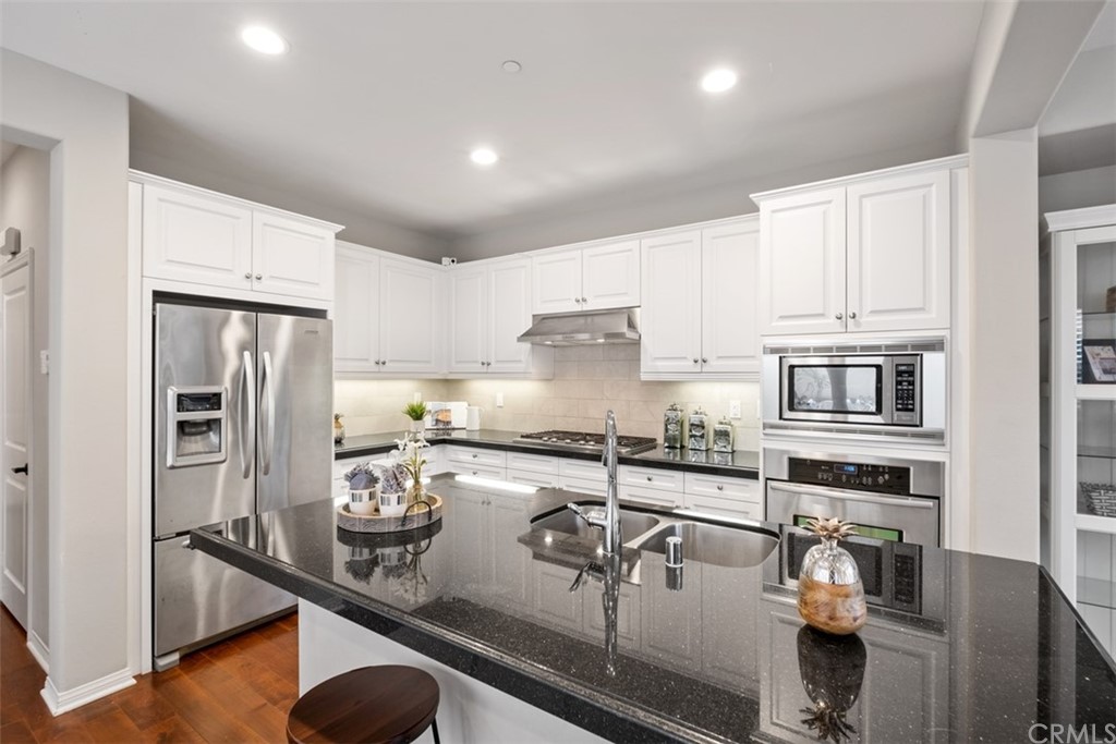 128 Long Grass Irvine, CA 92618 - Photo 12 of 42 a kitchen with stainless steel appliances granite countertop a sink refrigerator and cabinets