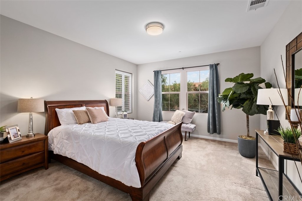 128 Long Grass Irvine, CA 92618 - Photo 21 of 42 a bedroom with a bed table flowerpot and a window