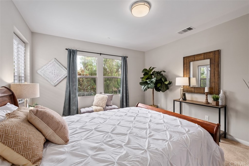 128 Long Grass Irvine, CA 92618 - Photo 22 of 42 a bedroom with a large bed and a potted plant