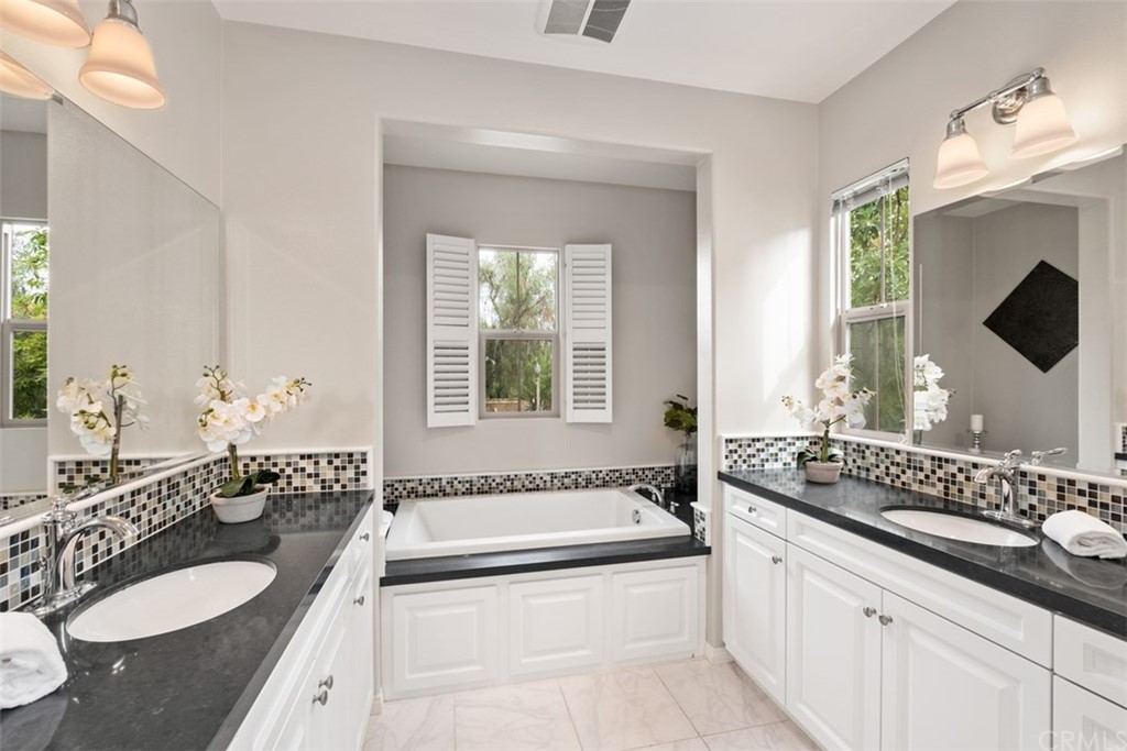 128 Long Grass Irvine, CA 92618 - Photo 23 of 42 a spacious bathroom with sinks mirror and a bathtub