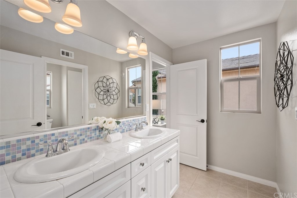 128 Long Grass Irvine, CA 92618 - Photo 28 of 42 a bathroom with a double vanity sink and a mirror
