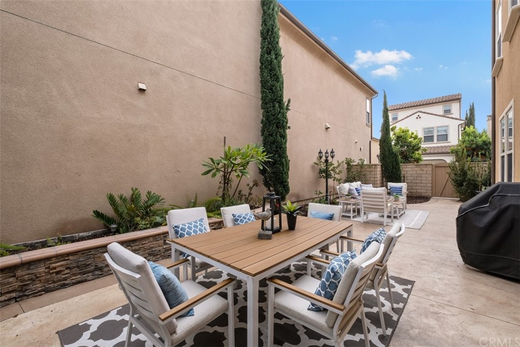 128 Long Grass Irvine, CA 92618 - Photo 37 of 42 a view of a patio with a dining table and chairs with potted plants