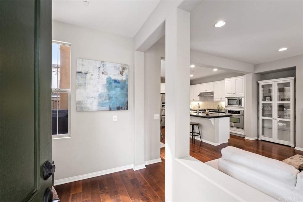 128 Long Grass Irvine, CA 92618 - Photo 6 of 42 a living room with stainless steel appliances kitchen island granite countertop a refrigerator and wooden floor