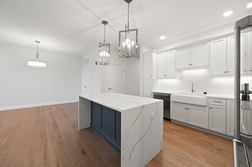 60 Coppersmith Way, Unit 404 Canton, MA 02021 - Photo 11 of 42 a kitchen that has a lot of cabinets in it and wooden floor