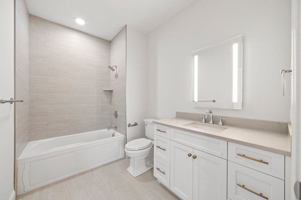 60 Coppersmith Way, Unit 404 Canton, MA 02021 - Photo 17 of 42 a bathroom with a granite countertop sink a toilet and bathtub