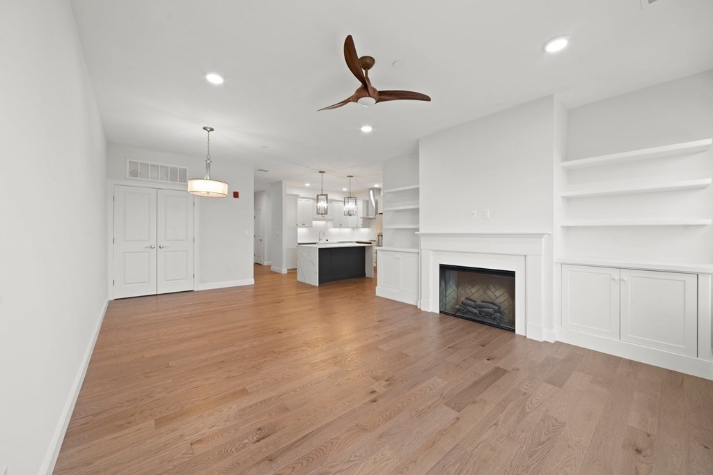 60 Coppersmith Way, Unit 404 Canton, MA 02021 - Photo 5 of 42 a view of empty room with kitchen and fireplace