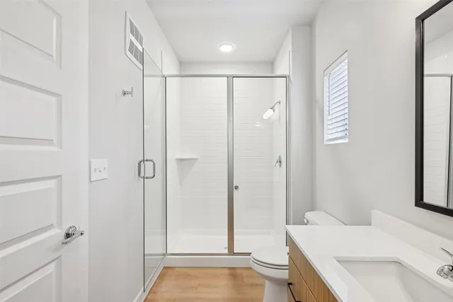 a bathroom with a sink a toilet and shower