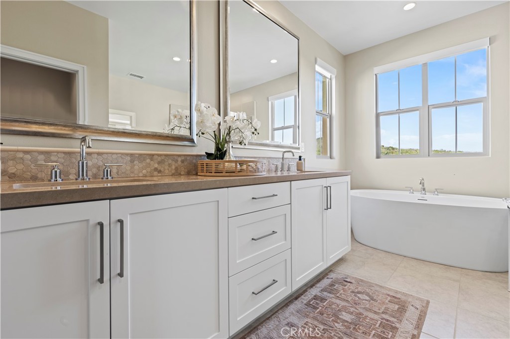 128 Tomahawk Irvine, CA 92618 - Photo 36 of 62 a bathroom with a double vanity sink a mirror and a bathtub