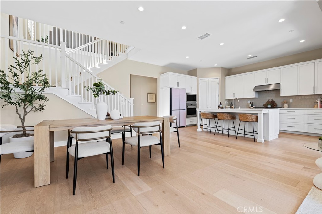 128 Tomahawk Irvine, CA 92618 - Photo 8 of 62 a kitchen with stainless steel appliances kitchen island granite countertop a table and chairs in it