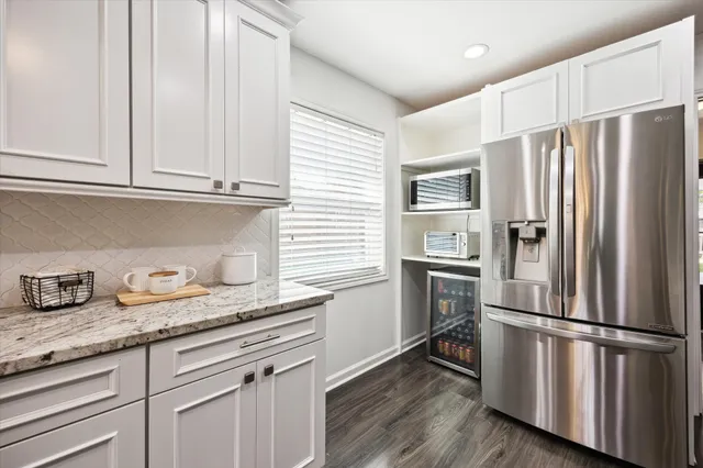 a kitchen with granite countertop stainless steel appliances a refrigerator and a sink