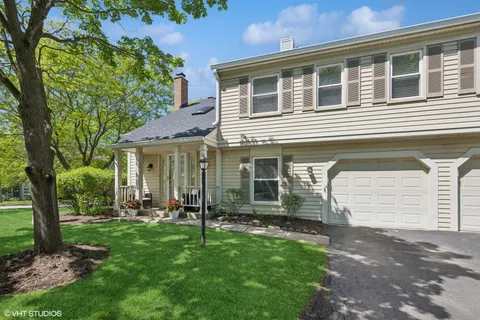 a front view of a house with a garden and plants