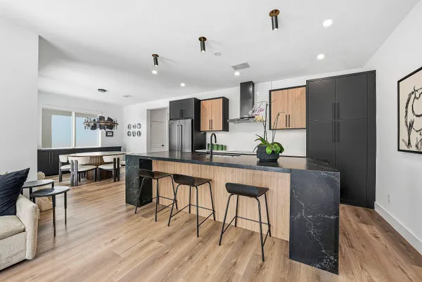 a kitchen with stainless steel appliances granite countertop a sink a stove and refrigerator