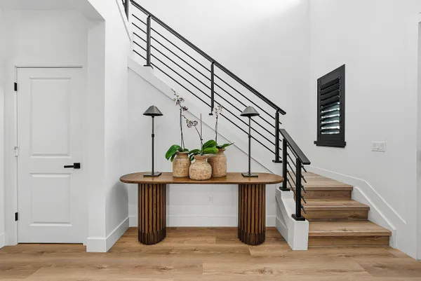 a kitchen with stainless steel appliances granite countertop a refrigerator a stove a sink a dining table and chairs with wooden floor